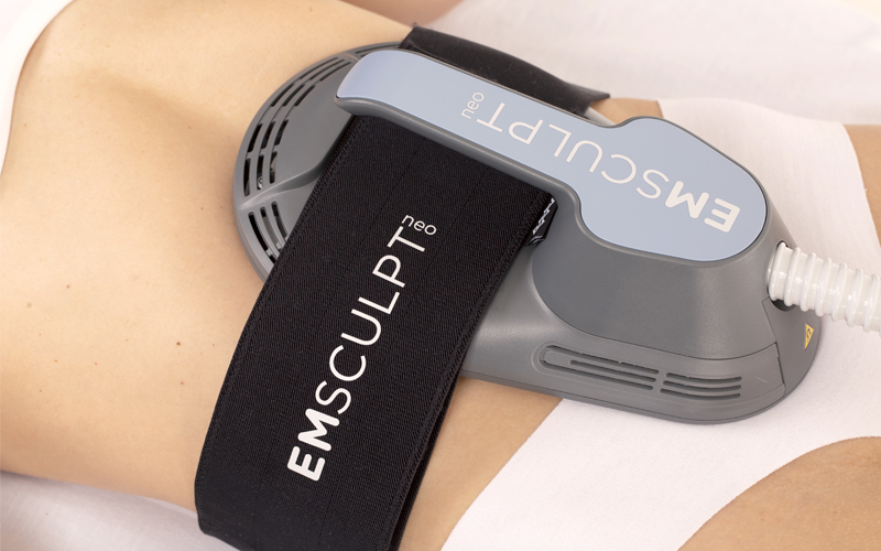EmSculpt Neo equipment being used around the waist on a woman